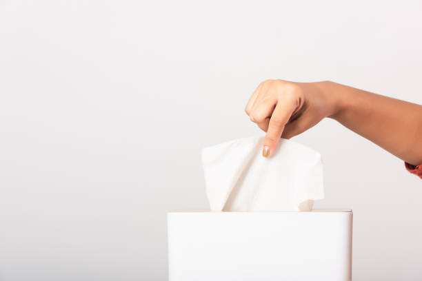 istock Hand taking pulling white facial tissue out of from a white box 1250472740