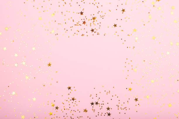 A bodrer made with falling confetti on pink background. A bodrer made with falling confetti on pink background. Perfect for festive and holidays projects. Copy space for your text. star shape photos stock pictures, royalty-free photos & images