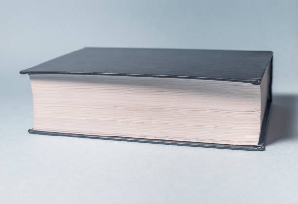 istock White and black closed thick book isolated on gray blue background, single object. reading concept 1250473663