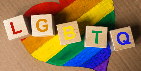Alphabetic colorful cube of LGBTQ word letters acronym on lgbtq flag in heart form
