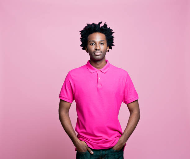 retrato de jovem vestindo camisa polo rosa - polo shirt african ethnicity men african descent - fotografias e filmes do acervo