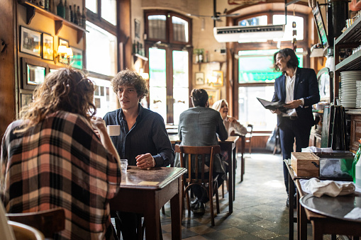 Local cafe in the morning with customers, people sitting and drinking coffees, Buenos Aires