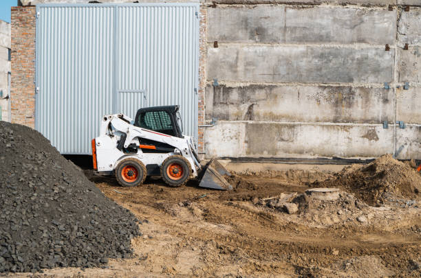 White skid steer loader at a construction site working with a soil. Industrial machinery. Industry. stock photo