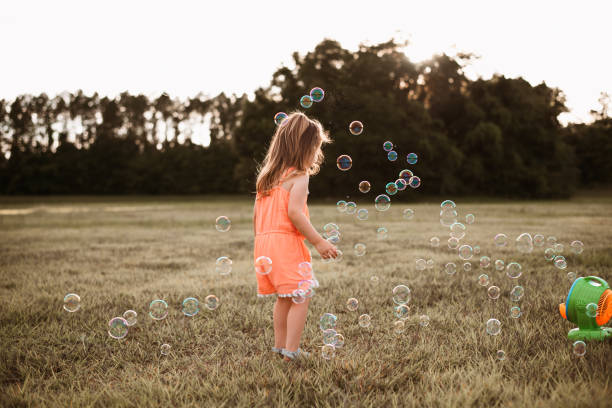 istock Girl playing with soap bubbles 1250478302