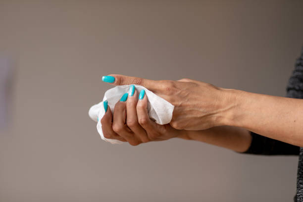 istock Old woman gently cleaning hands with wet wipes 1250480035