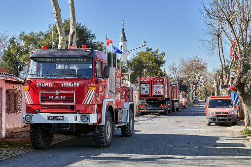Istanbul, Turkey - February 13, 2020: A fleet of fire engines in the Adalar District, Buyukada Island, one of the Prince Islands. Red fire protection trucks stand along the side of the road.