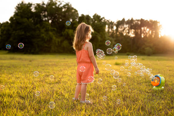 istock Girl playing with soap bubbles 1250482537