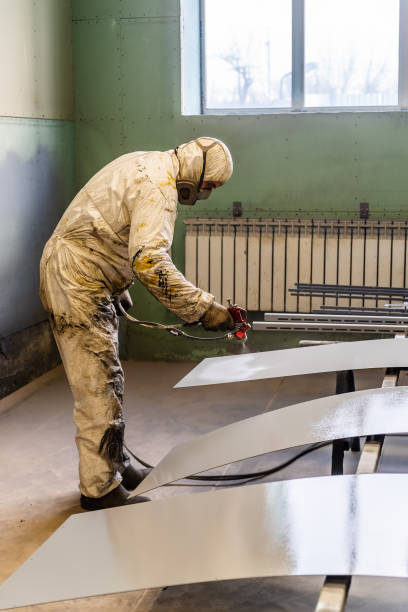 istock The painter in protective overalls works in the paint shop 1250482882