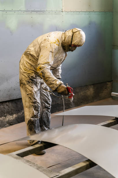 istock A painter in protective overalls works with a spray gun in a paint shop 1250483234