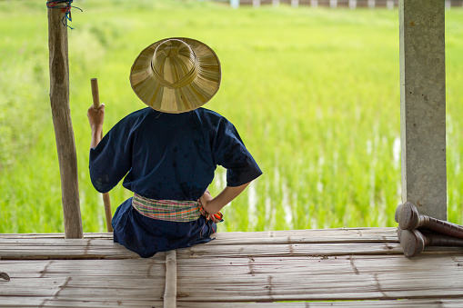 son of asian farmer sitting on table and looking to rice farm