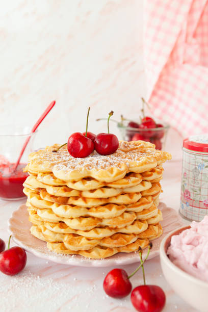 Homemade sweet waffles with fresh cherries and cream
