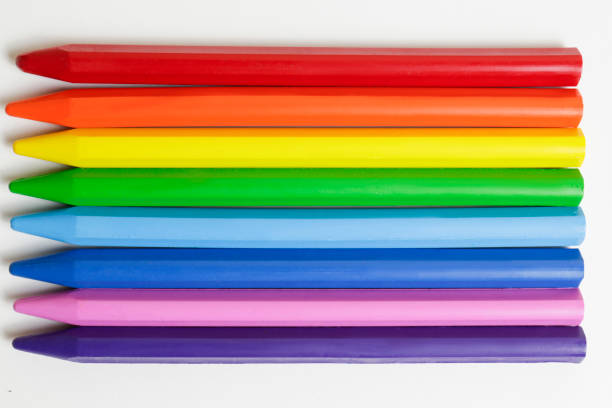 Bunch of different colorful crayon pencils laid out in creative rainbow spectrum composition symbolizing the sexual minorities community. Close up, copy space, top vie, flat lay, conceptual background