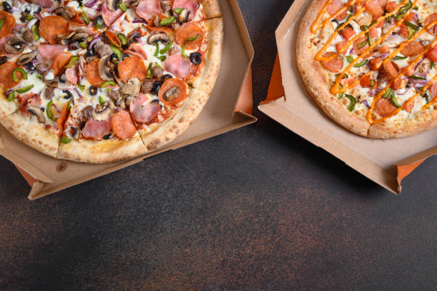 istock Delivered Italian pizzas with tomato, pepperoni, pepper, Mozzarella cheese. Food pattern. Copy space. 1250489429