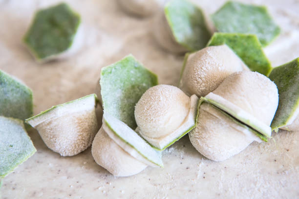 istock raw two-tone white and green dumplings with spinach, cheese or meat on a table with flour 1250489591