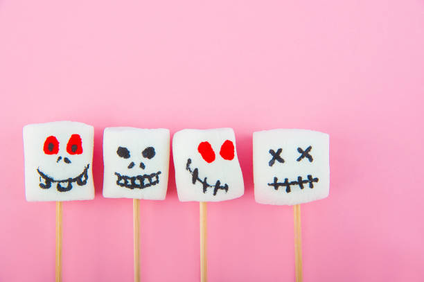 istock Marshmallows close-up and copy space on a pink background. Marshmallows for Halloween emoticons. 1250489602