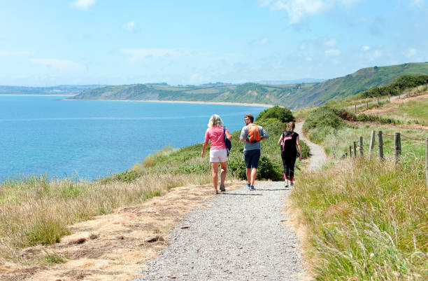 West Bay, UK. Saturday 12 September 2020. A woman walking on the South West Coast Path with the Distinctive West Bay Cliffs in Dorset