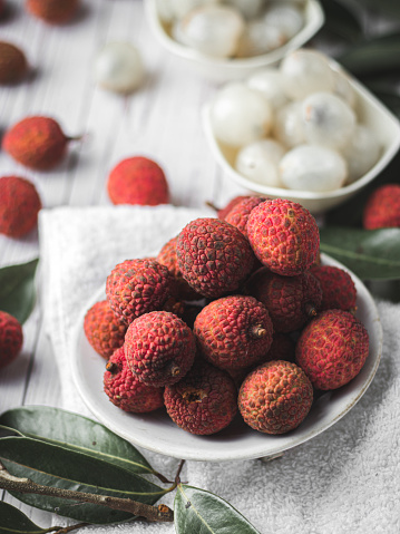 Lychee fruits with leaves on white backgrounds.