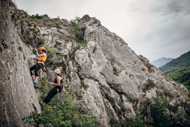 istock Strong women free climbers climbing high 1250491653