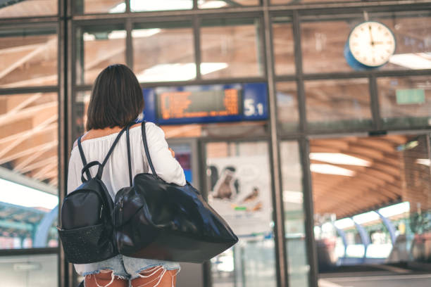 istock Young woman with bag and backpack in the trainstation 1250494657