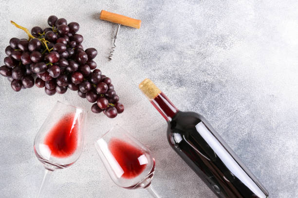 istock Juicy black grapes with wineglasses on textured background. 1250495341