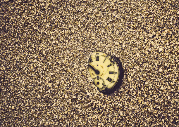 Sands of time Antique rotten pocket watch buried partial in the sand. broken pocket watch stock pictures, royalty-free photos & images