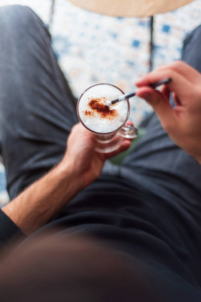 Abstract close up shot of cappuccino foam coffee drink glass, blur background.