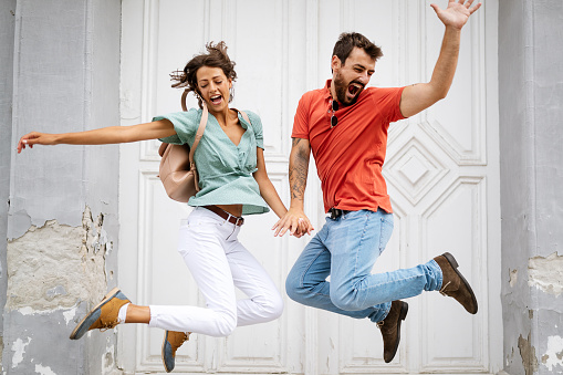 Happy loving couple having fun and jumping outdoors