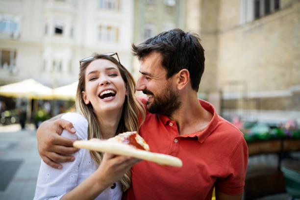 istock Happy couple eating pizza while traveling on vacation 1250499692