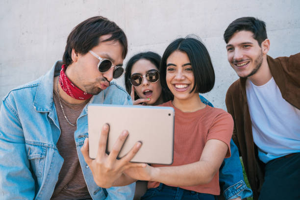 istock Friends using digital tablet together outdoors. 1250503017