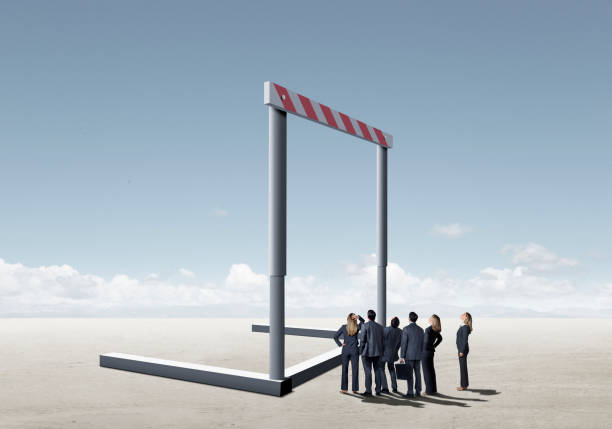 Business Hurdle A group of business people look up at a giant hurdle that stands before them. hurdle stock pictures, royalty-free photos & images