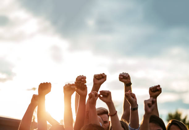 manifestantes levantando los puños - derechos humanos fotografías e imágenes de stock