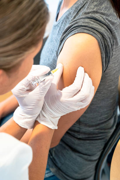 女性医師が女性患者にワクチンを接種する垂直的見解 - gauze healthcare and medicine disposable bandage ストックフォトと画像