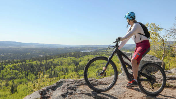 istock Female mountain e-biker relaxes on mountain ridge 1250508931