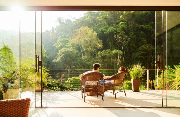 Couple in a vacation Rear view of a couple relaxing in the chairs at hotel balcony exclusive travel stock pictures, royalty-free photos & images