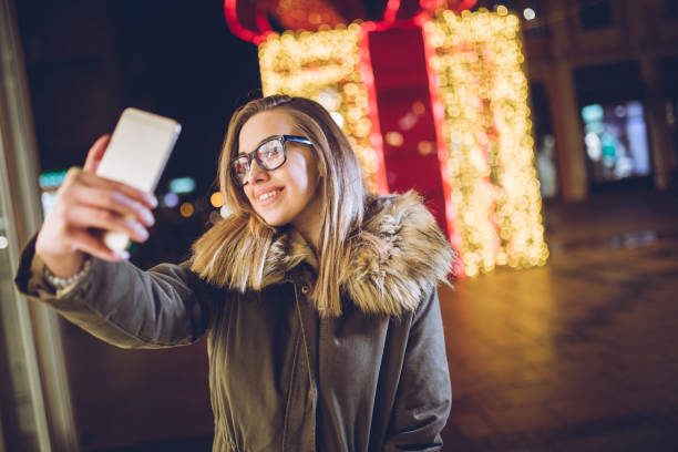 istock Woman making selfies downtown at night 1250510481