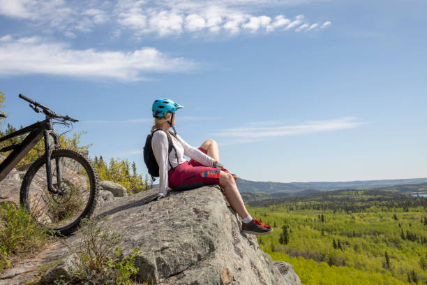 istock Female mountain e-biker relaxes on mountain ridge 1250514129
