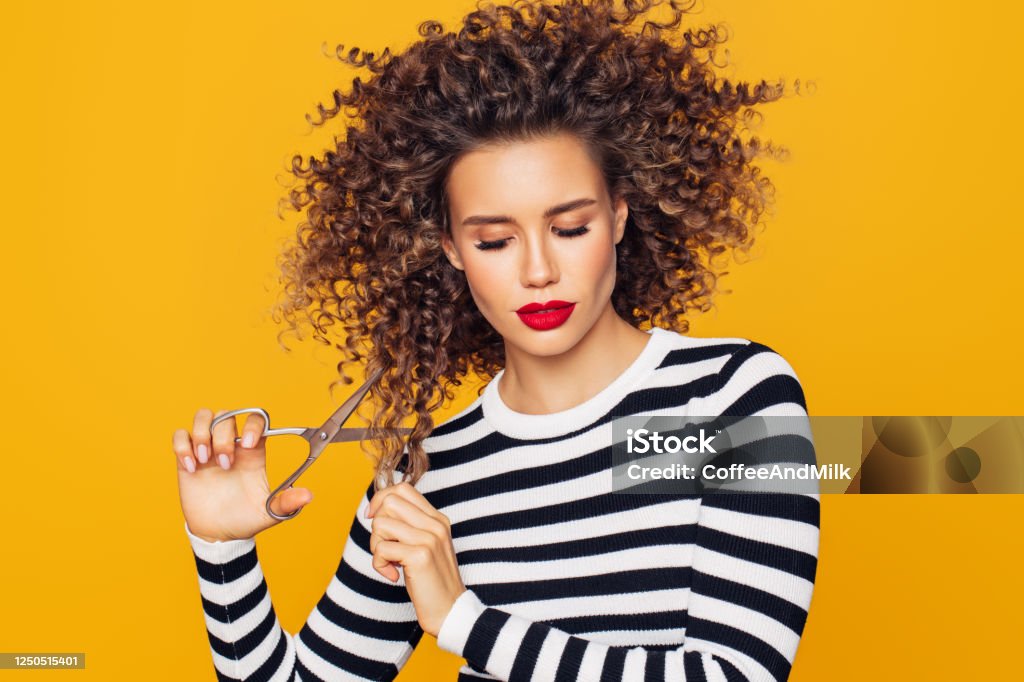 Close-up photo of a beautiful girl holds hair scissors and ready to change her hairstyle Cutting Stock Photo
