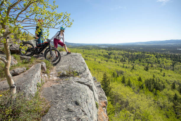 istock Couple on mountain e-bikes relax on mountain ridge 1250515439