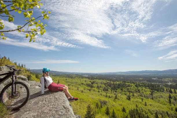 istock Female mountain e-biker relaxes on mountain ridge 1250516800