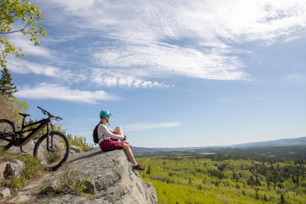 istock Female mountain e-biker relaxes on mountain ridge 1250516852