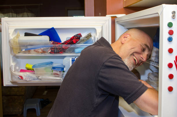 istock Man with head in freezer during heat wave 1250517452