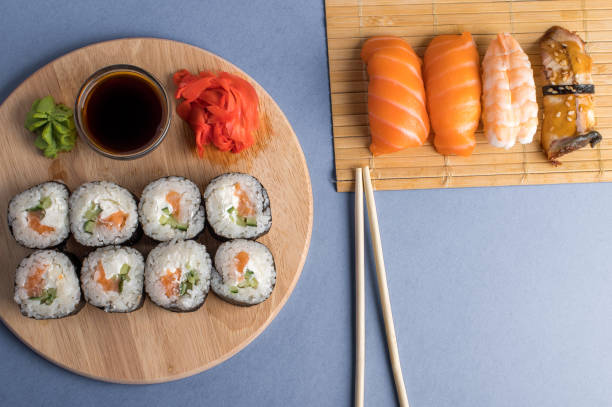 komposition mit köstlichem nigiri-sushi und brötchen - chopsticks soybean japanese cuisine blue stock-fotos und bilder