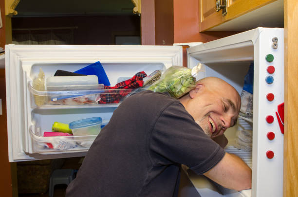istock Man with head in freezer during heat wave 1250517474