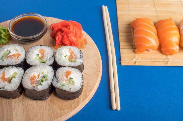 komposition mit köstlichem nigiri-sushi und brötchen - chopsticks soybean japanese cuisine blue stock-fotos und bilder