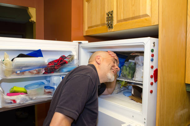 istock Man with head in freezer during heat wave 1250518102