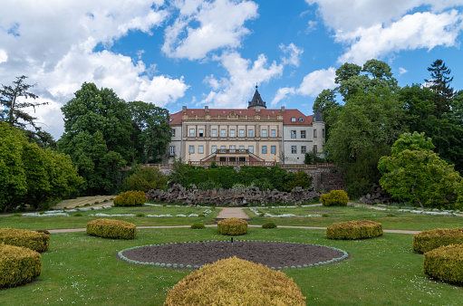 Wiesenburg, Brandenburg, Germany - June 6, 2020: View of garden and building against cloudy sky.