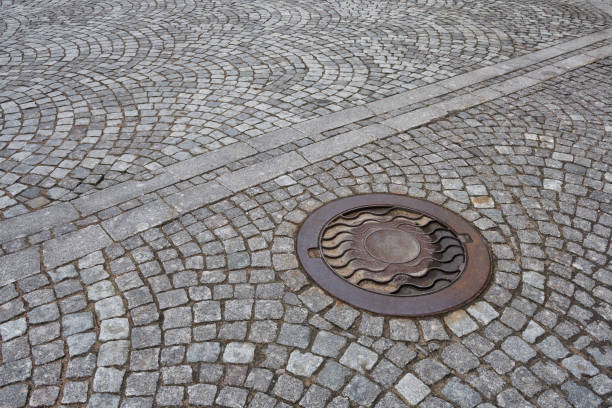 Sewer manhole on a city road.This is a heavy iron cover.