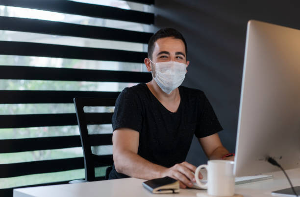 istock Young businessman with protective face mask is working in the home office 1250521149