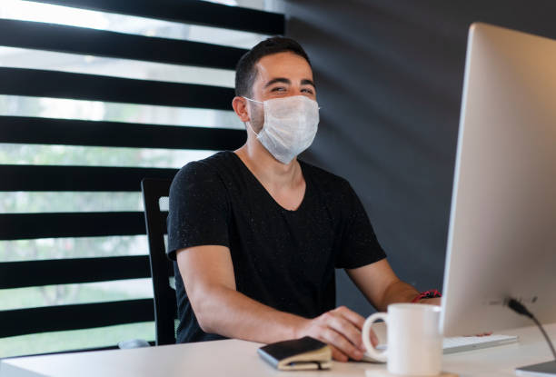 istock Young businessman with protective face mask is working in the home office 1250521177