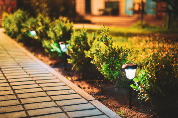 istock Night View Of Flowerbed Illuminated By Energy-Saving Solar Powered Lanterns Along The Path Causeway On Courtyard Going To House 1250523166